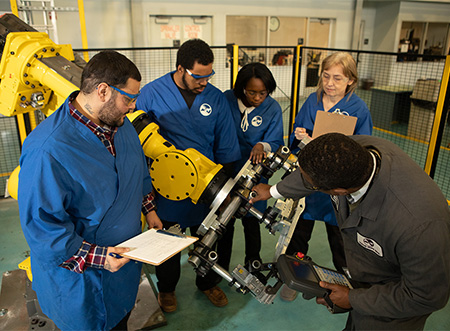 El grupo inspecciona el brazo robótico en el centro de formación