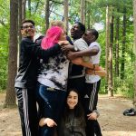 Un grupo de adolescentes se abraza en un campamento forestal
