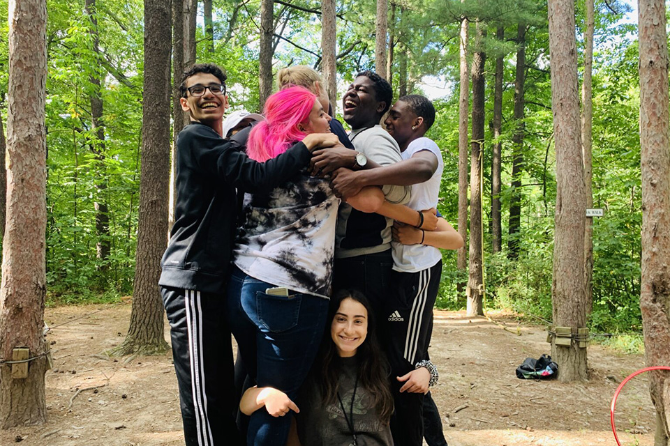 Un grupo de adolescentes se abraza en un campamento forestal