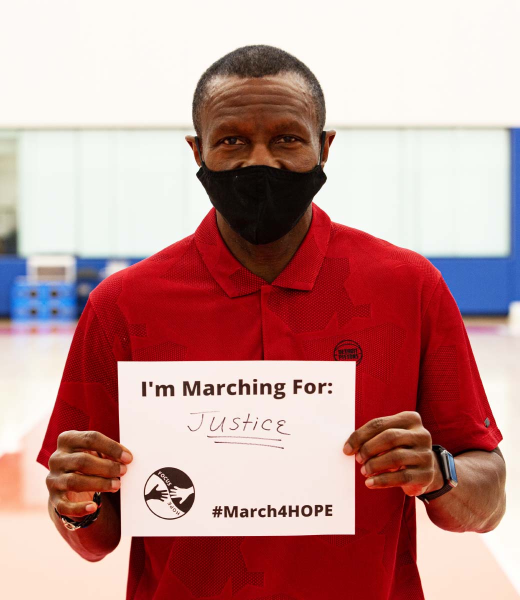 Comunidad y defensa - Hombre con un cartel de &quot;Marching for Justice&quot; (Marcha por la Justicia)
